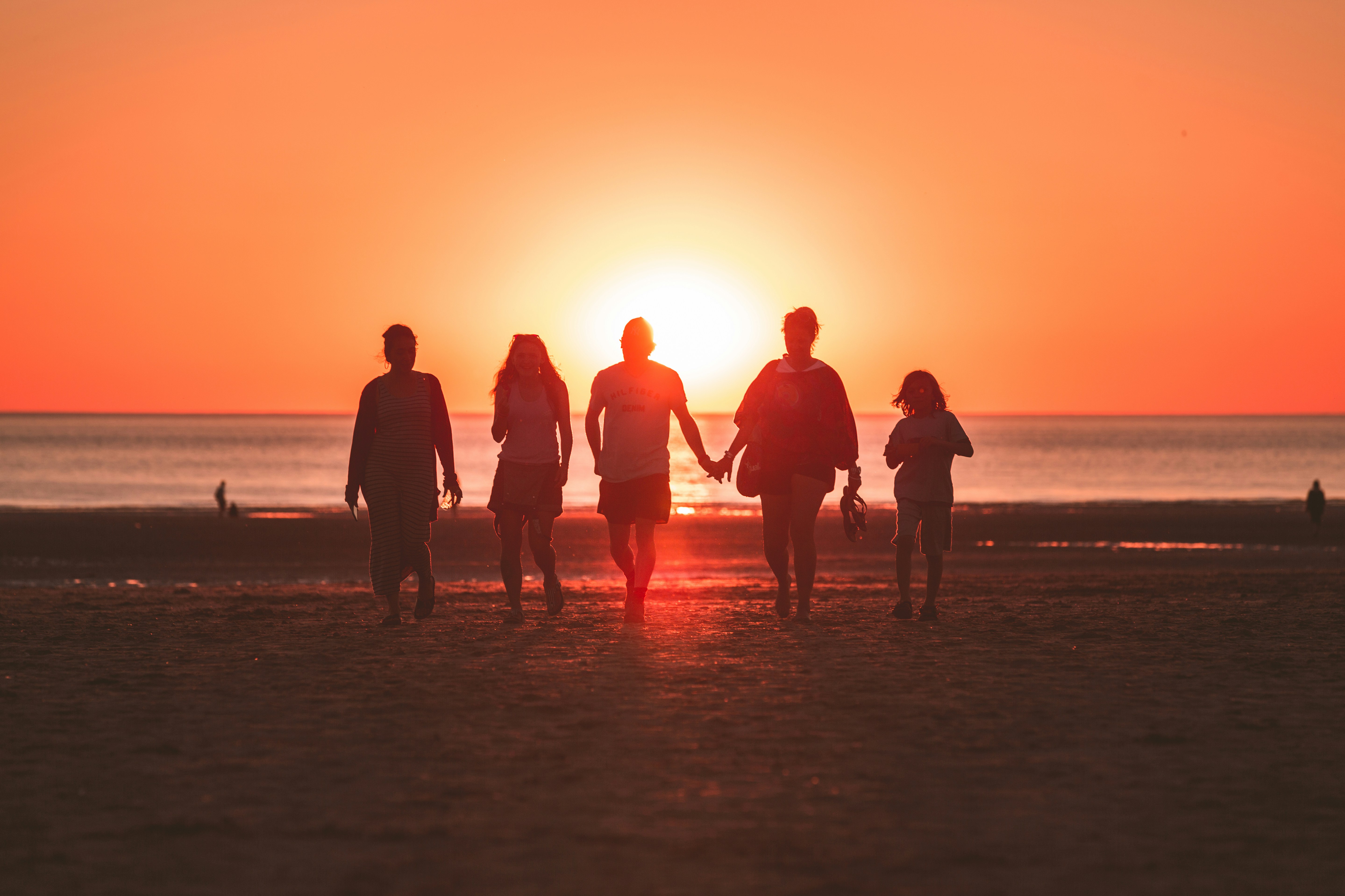 A family walking together on the beach at sunset